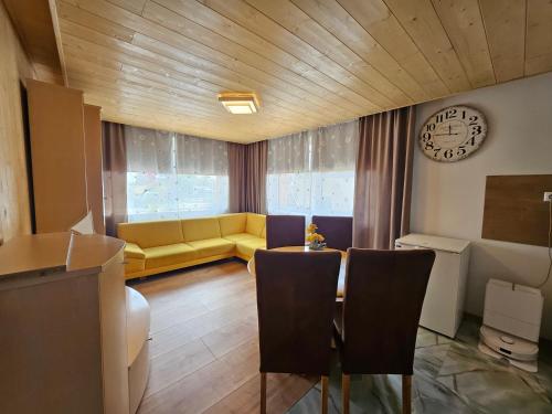 a living room with a yellow couch and a table at Wellness Toliar Tatry in Stará Lesná