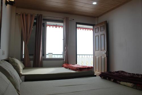 a bedroom with a bed and a window and a door at Nijung Homestay, Dowhill in Kurseong
