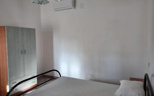 a bedroom with a bed and a cabinet at Villeriunite - Villetta numero 6 in Baia Verde