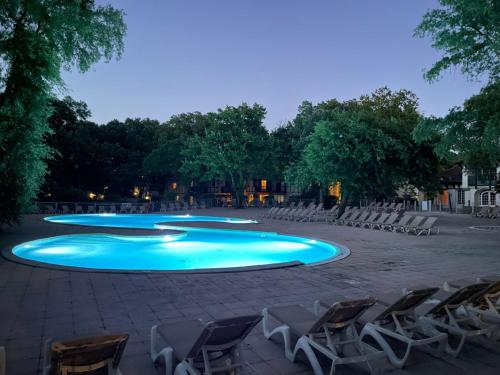 a group of chairs and a swimming pool at cottage « maison du golf » à Moliets in Moliets-et-Maa