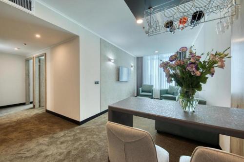 a lobby with a table with a vase of flowers at Expocore Hotel in Yerevan