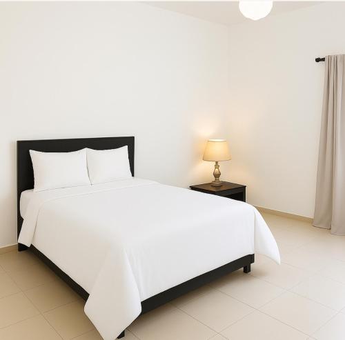 a white bed in a white room with a lamp at Havillah Court, Regent 