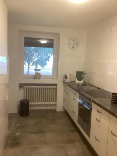 a kitchen with a sink and a stove top oven at Ferienwohnung Wohnung Krefeld Forstwald Höltehoffe in Krefeld