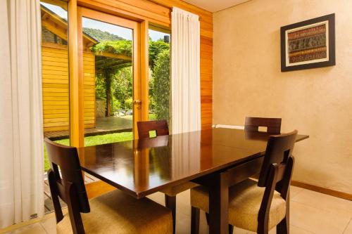 a dining room with a table and chairs and a window at Del Sauco Apart & Spa in San Martín de los Andes