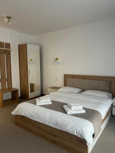 a bedroom with a large bed with towels on it at Vila Marbo in Baile Felix