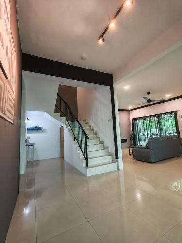 a living room with a staircase and a couch at Air-home M1 Simpang near Aulong Econsave, 4BR, 10pax, Netflix in Simpang