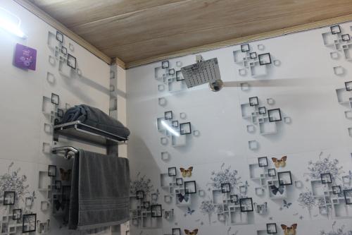 a bathroom with a wall with pictures on the wall at Nijung Homestay, Dowhill in Kurseong