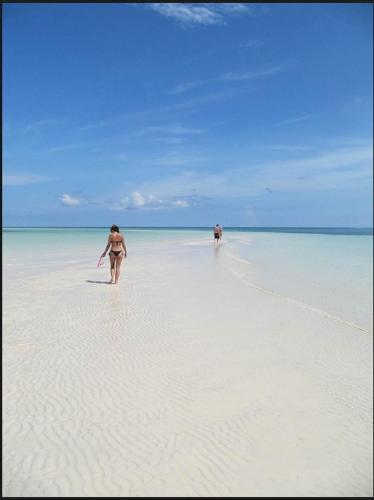 two people walking on a beach in the water at The Blue Inn Family Vacation Rental in Smith Point