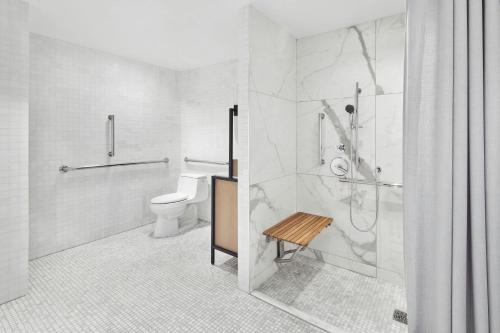 a white bathroom with a toilet and a shower at The Luxury Collection Hotel Manhattan Midtown in New York