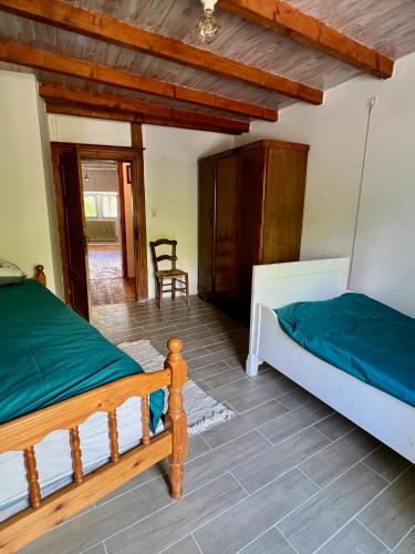 a bedroom with two beds and a chair at Gîte La Vésarnie in Montaigu-de-Quercy
