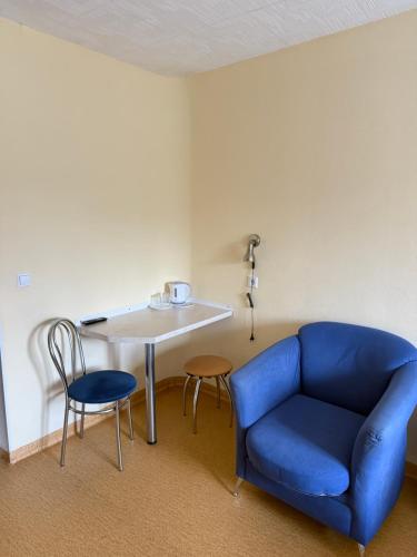 a room with a blue couch and a table and chairs at Velga in Vilnius
