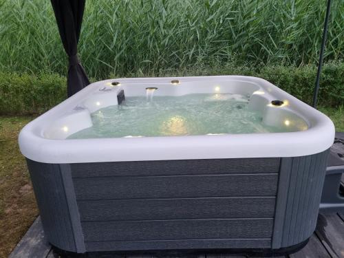 a jacuzzi tub sitting on a deck at Vrijstaande woning met jacuzzi in grote tuin in Ewijk