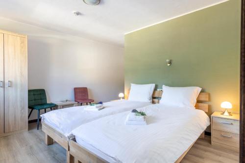 a bedroom with two beds and two chairs at Garni Hotel im Fachwerkhof in Simmerath