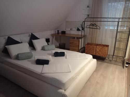a white bed with pillows in a room at Shining Home in Felsőörs