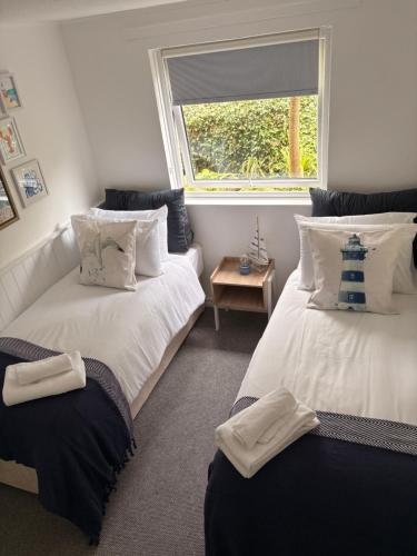 a bedroom with two beds and a window at The Hideout in Carbis Bay