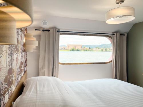 a bed in a room with a large window at LA PÉNICHE - Hisseo in Tain-lʼHermitage