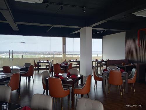 a dining room with tables and chairs and large windows at OCEAN BREEZE - WAVES LUXURY CONDO in Negombo