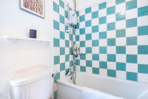 a bathroom with a green and white checkered wall at Cosy and central Belfast House in Belfast