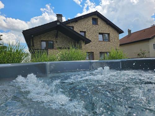a pool of water in front of a house at Wellness Toliar Tatry in Stará Lesná
