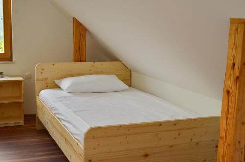 a bed in a room with a wooden frame at Koča v Lozah in Gornji Grad