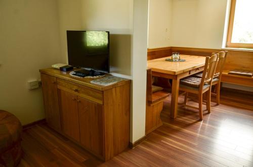 a dining room with a table and a television on a cabinet at Koča v Lozah in Gornji Grad