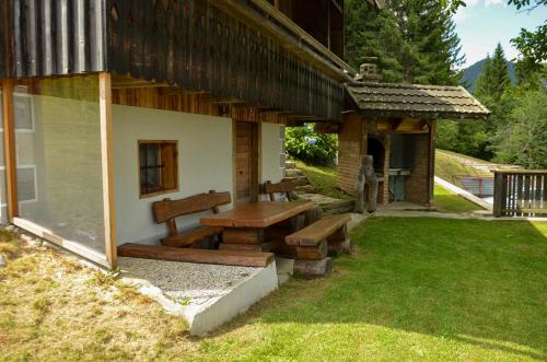 a bench on the side of a house at Koča v Lozah in Gornji Grad