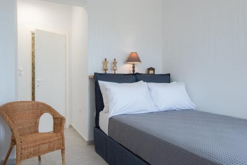 ein Schlafzimmer mit einem Bett, einem Stuhl und einer Lampe in der Unterkunft Apelagitis 3 in Sifnos