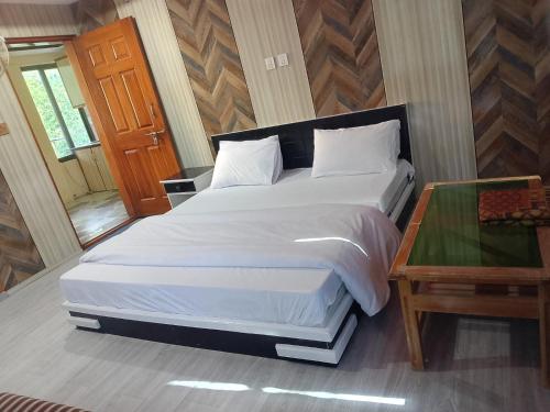 a bedroom with a large white bed and a table at Pacific Guest House Skardu in Skardu