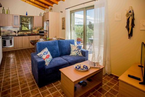 a living room with a blue couch and a table at Maniata Holiday Apartments in Andipáta Erísou