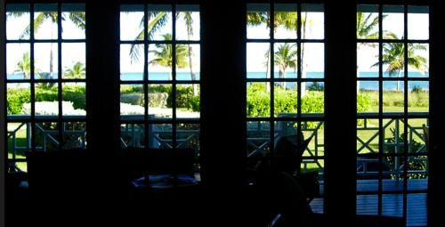 a room with a view of the ocean through windows at The Blue Inn Family Vacation Rental in Smith Point