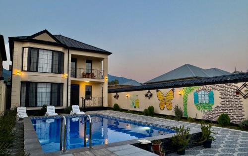 a house with a swimming pool in front of a building at Gabala Double Villas in Gabala