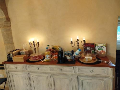 un buffet con due candele sopra di Les Communs de Chiffrevast a Tamerville