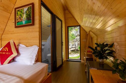 a bedroom with a bed and a window in a room at Hoang Minh Mountainside Villa in Ninh Binh