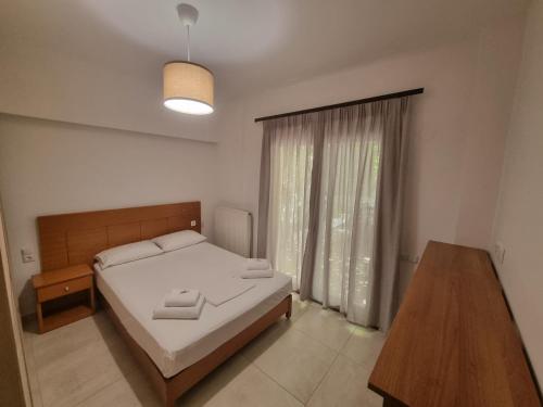 a bedroom with a bed and a table and a window at On The Rocks in Theologos