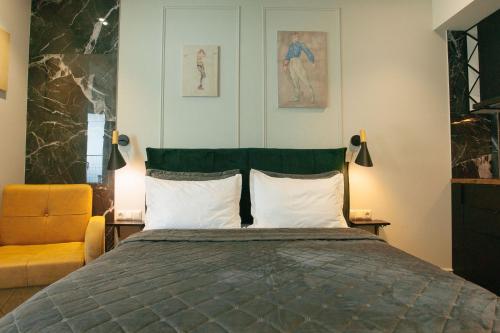 a bedroom with a bed and a yellow chair at Beach Apartment in Batumi