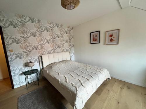 Un dormitorio con una cama y una pared. en Au théâtre, en Colmar