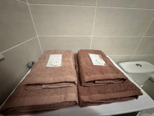 a bathroom with three towels sitting on top of a toilet at Квартира посуточно Одесса, ЖК Артвиль, Аквапарк in Odesa