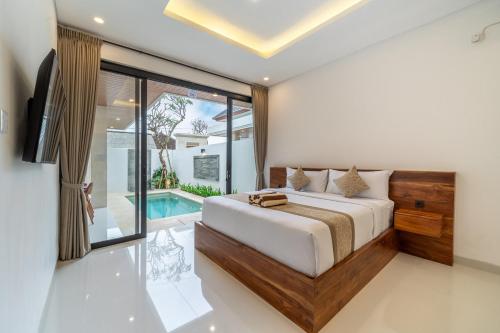 a bedroom with a bed and a swimming pool at Bramasta Villa in Ubud