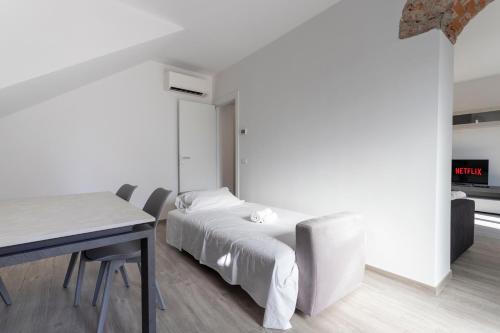 a white bedroom with a bed and a table at Residence Risorgimento in Novara