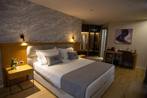 a bedroom with a large bed and a desk at White Hill Hotel, SPA & Conferences in Durrës