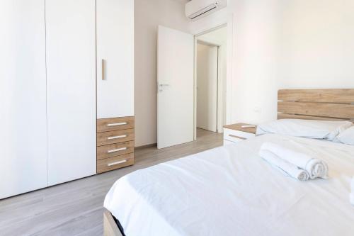 a white bedroom with two beds and white cabinets at Residence Risorgimento in Novara
