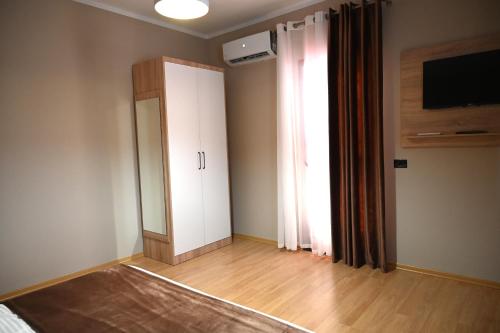 a room with a closet and a door and a television at Fly Rooms in Krujë