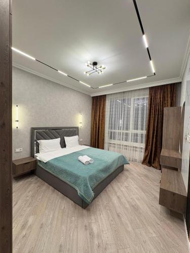 a bedroom with a large bed and a window at Панорамная евродвушка комфорт-класса in Almaty
