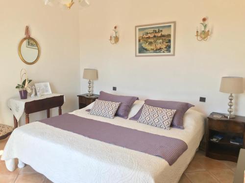 a bedroom with a large bed with purple pillows at Bastide Rose de Mai in Le Rouret