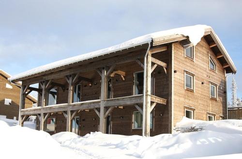 a large wooden building with snow on top of it at Fjallhus Storhogna 2 in Storhågna