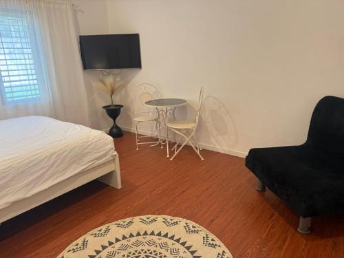 a bedroom with a bed and a table and chairs at סתלבט בקיבוץ in Hagoshrim