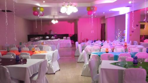 a banquet hall with white tables and pink walls at Hotel Caribe Panamá in Panama City