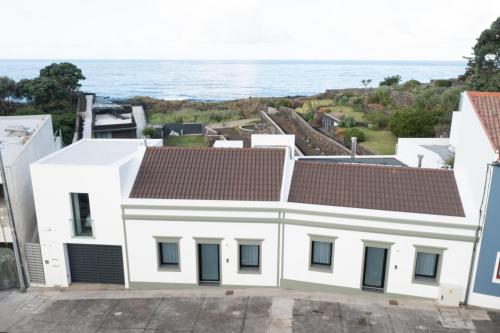 a white house with the ocean in the background at Oceanside Village 1 in Lagoa