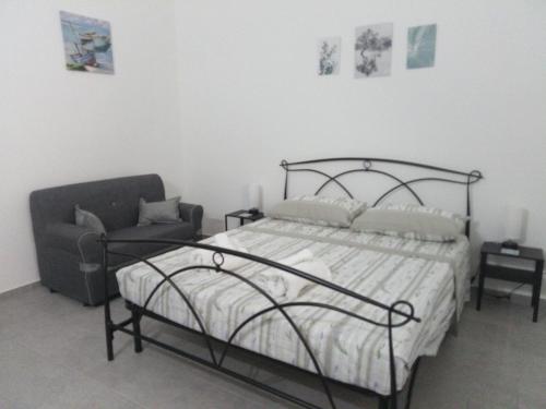 a bedroom with a bed and a chair at Apulian Bluemoon House in Molfetta