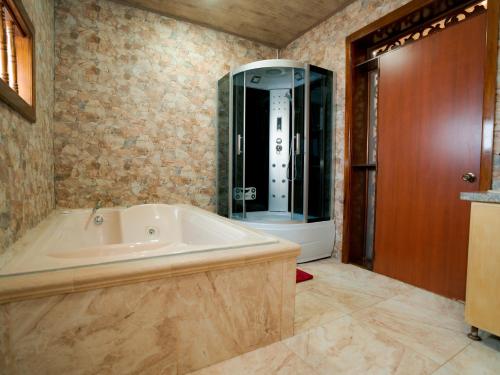 a bathroom with a tub and a glass shower at Salamina Highs in Salamina
